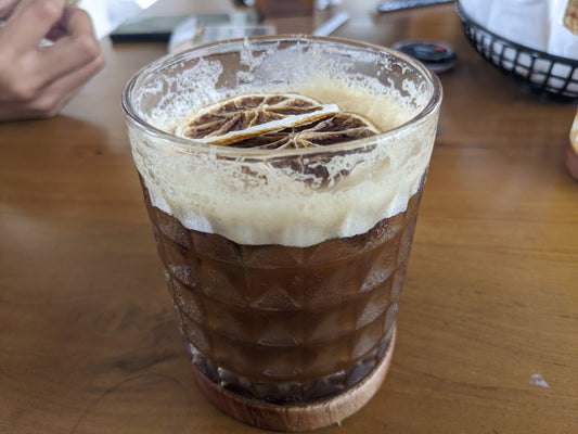 Close-up of a nitrogen-infused cold brew coffee with foamy top in a clear glass